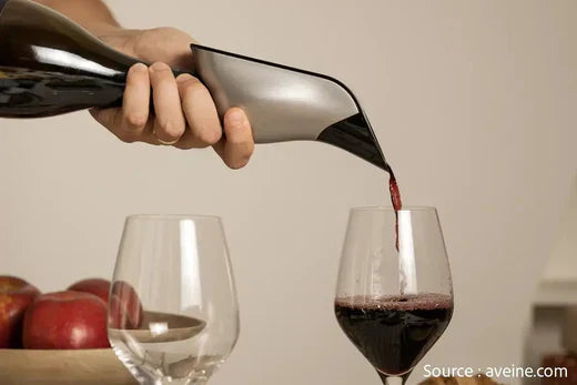 Aérateur de vin en utilisation. Un personne est en train de servir du vin rouge dans un verre de vin.