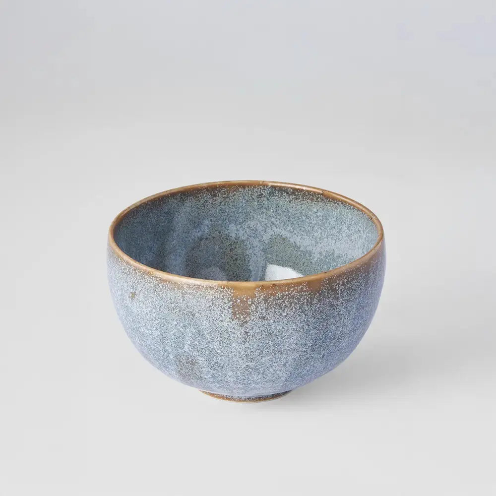 Bolée de cidre en céramique, finition artisanale avec un émaillage bleu moucheté et un rebord brun doré. Un design authentique inspiré des traditions, idéal pour déguster un cidre ou toute autre boisson. Présentée sur fond blanc pour mettre en valeur ses textures et son élégance.