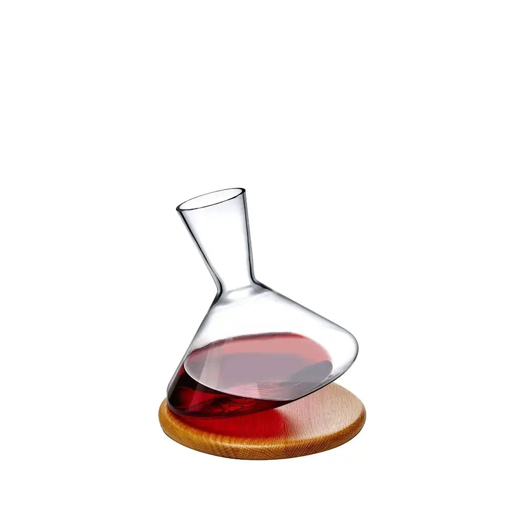 Carafe à vin Balance en cristal sur socle en bois, présentée sur fond blanc, remplie de vin rouge.