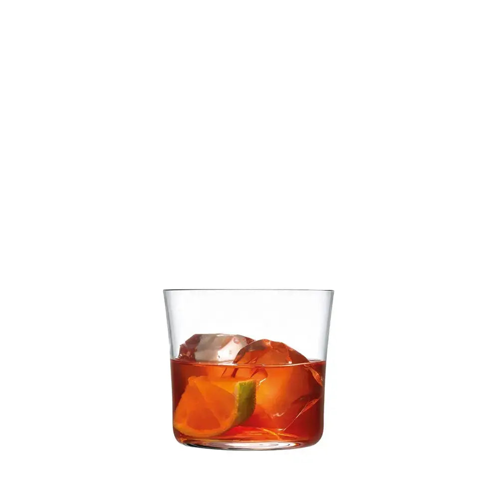 Verre à cocktail Lowball rempli, avec glaçons et zestes d’agrumes, sur fond blanc.