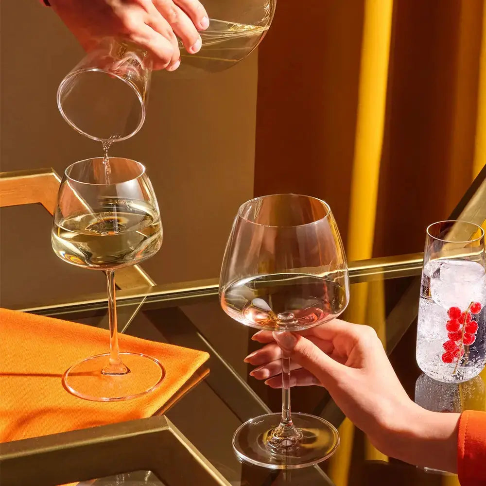 Set de 2 verres à vin Chardonnay. Scène de dégustation élégante avec service de vin blanc dans un intérieur chaleureux.
