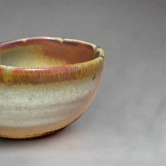 Vue rapprochée d'une bolée de cidre traditionnelle, mettant en valeur les nuances d'émail et la texture du matériau.