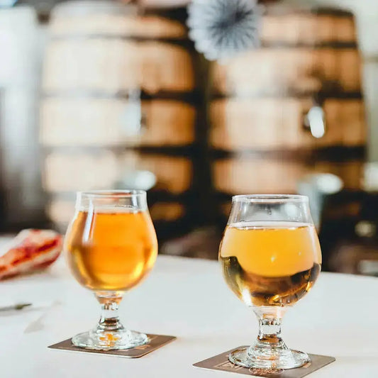 Ensemble de 2 verres pour cidre ballon. Il y a deux barriques en bois au fond.