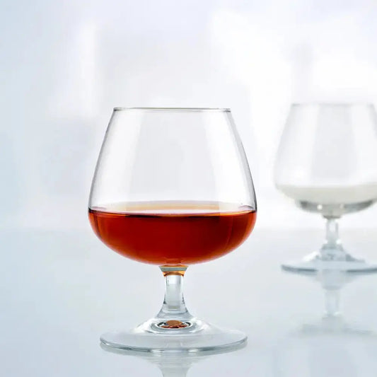 Lot de 2 verres ballon pour dégustation de cognac posés sur une table. 