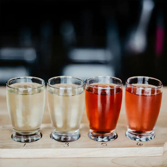 Set de 4 verres de cidre dans un bar. Les verres sont tous remplis de cidres différents.