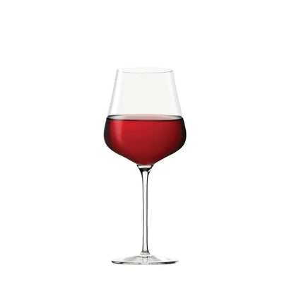 Verre à Bordeaux rempli de vin rouge sur fond blanc. 